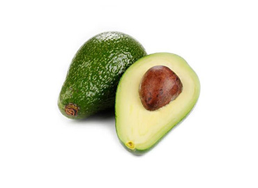 Aguacate fresco y maduro sobre una tabla de madera.