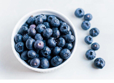 Arándanos frescos en un bol, ideales para snacks saludables y recetas.