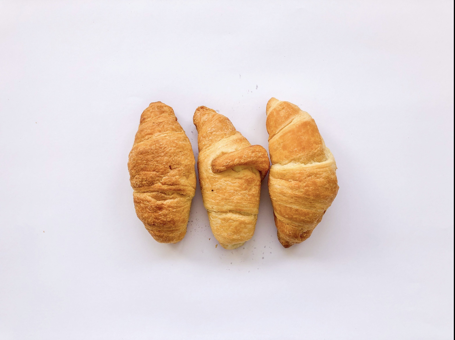 Croissants recién horneados en caja de 8 unidades con textura hojaldrada y dorada